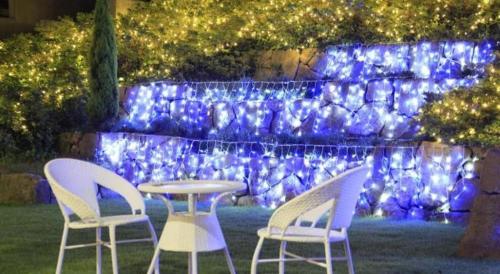 two chairs and a table in front of a wall with blue lights at Centurion Hotel Technoport Fukui- Artificial Radium Hot Spring in Sakai