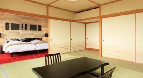 a bedroom with a bed and a black table at Centurion Hotel Technoport Fukui- Artificial Radium Hot Spring in Sakai