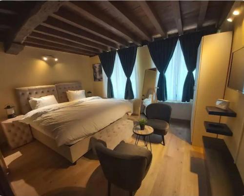 a bedroom with a large bed and two chairs at Family Heritage Grand Place in Brussels