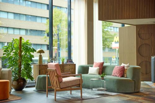 a living room with a couch and a table and chairs at Haven Hotel Rotterdam, Curio Collection by Hilton in Rotterdam