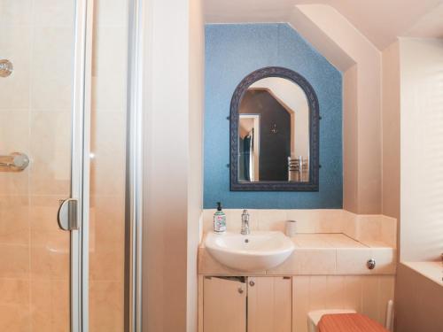 a bathroom with a sink and a mirror at Yarn Cottage in Broadway