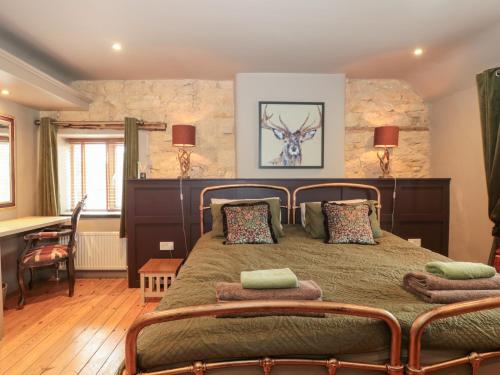 a bedroom with a large bed with two pillows at Yarn Cottage in Broadway