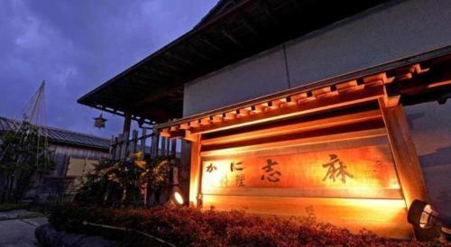 a building with writing on the side of it at Minshuku Shima in Kaga
