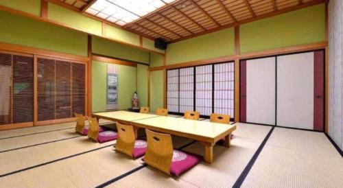 a large room with a table and chairs in it at Minshuku Shima in Kaga