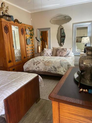 a bedroom with a bed and a table with a table sidx sidx sidx at Magalies B&B SPITSKOP in Bloemfontein