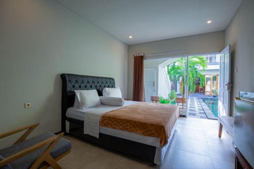 a bedroom with a bed and a sliding glass door at Villa Rose 1 Sanur in Sanur