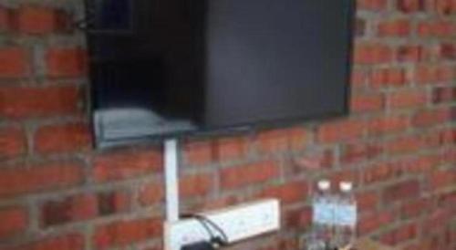a brick wall with a television on top of it at Rock & Roll Hotel Klang in Klang