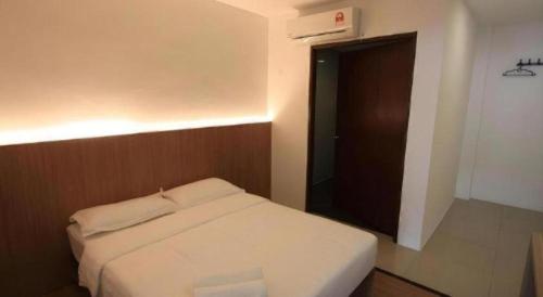 a bedroom with a white bed and a black door at Place2stay @ Campus Hub in Kuching