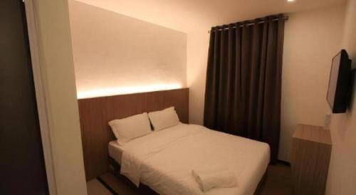 a small bedroom with a bed and a television at Place2stay @ Campus Hub in Kuching
