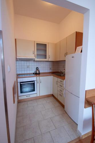 a kitchen with white cabinets and a white refrigerator at Penzion Růže in Humpolec