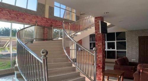 a spiral staircase in a building with a living room at PAHANG REST HOUSE @ BERA in Temerloh