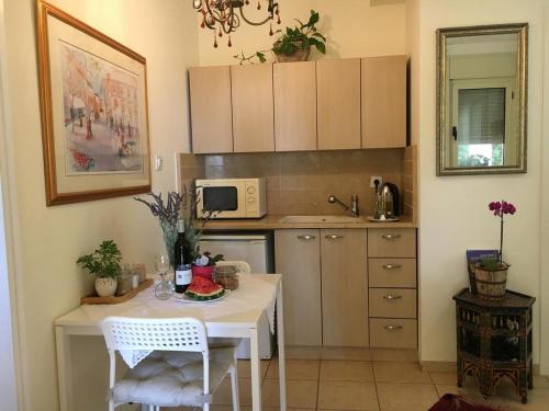 a small kitchen with a white table and chairs at פינת נופש- סויטת הרימון עם בריכה פרטית - 6 אורחים in Rosh Pinna
