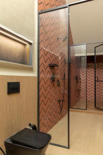 a bathroom with a glass shower with a toilet at Scarlatta in Ghoti Budrukh
