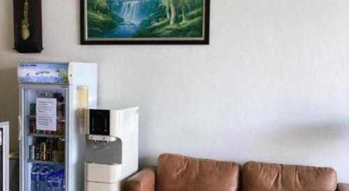 a living room with a couch next to a refrigerator at Power Hotel in Georgetown
