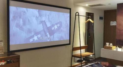 a projection screen on a wall in a room at James Joyce Coffetel·Shijiazhuang Economic and Technological Development Zone Chuangye Road in Shijiazhuang