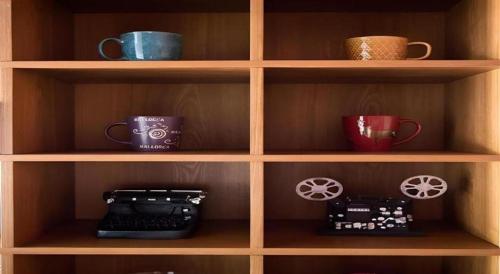 a wooden shelf with cups and mugs on it at James Joyce Coffetel·Shijiazhuang Economic and Technological Development Zone Chuangye Road in Shijiazhuang