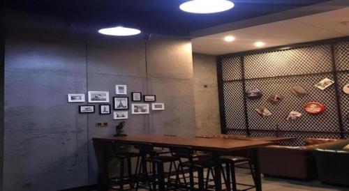 a table in a room with some pictures on the wall at James Joyce Coffetel·Shijiazhuang Economic and Technological Development Zone Chuangye Road in Shijiazhuang