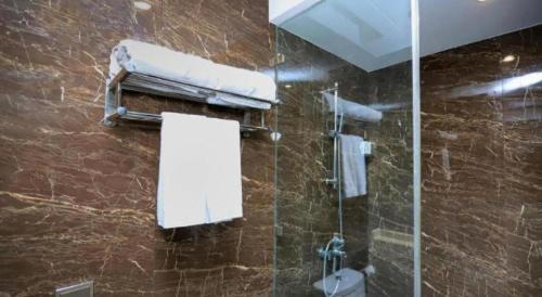a bathroom with a shower with a toilet and a mirror at Zmax Changzhi Bayi Square in Changzhi