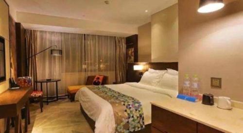 a hotel room with a bed and a desk at Zmax Changzhi Bayi Square in Changzhi