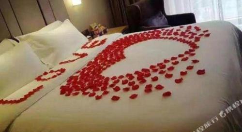 a bunch of red rose petals on a bed at Zmax Changzhi Bayi Square in Changzhi