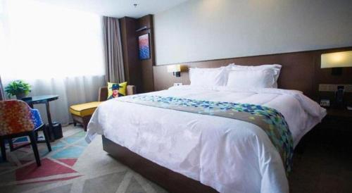 a hotel room with a large bed and a desk at Zmax Changzhi Bayi Square in Changzhi
