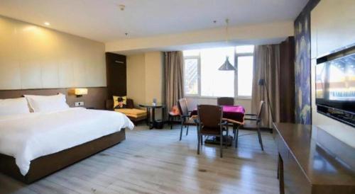 a hotel room with a bed and a living room at Zmax Changzhi Bayi Square in Changzhi