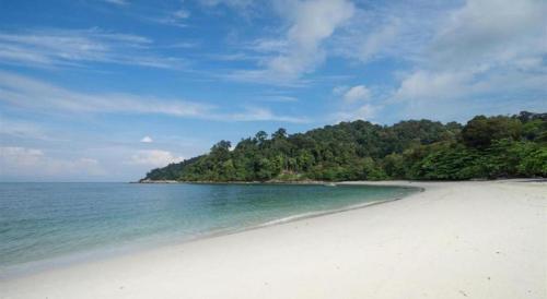 a white sandy beach with trees in the background at Hotel Pangkor Mutiara in Pangkor