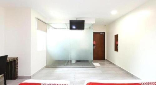 a room with a glass partition with a tv on the wall at OYO 718 Mr J Hotel Wakaf Che Yeh 1 in Kota Bharu
