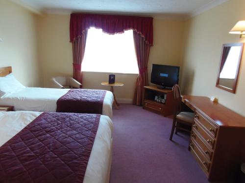 Кровать или кровати в номере Potters International Hotel