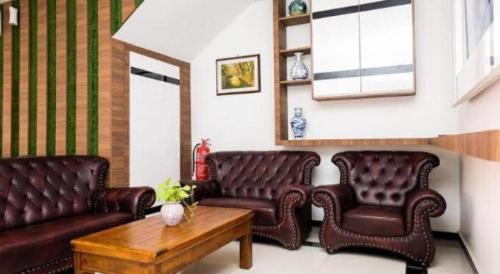 a living room with two leather couches and a table at OYO 718 Mr J Hotel Wakaf Che Yeh 1 in Kota Bharu