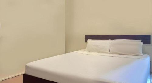 a bed with white sheets and pillows in a room at SPOT ON 91178 Motel Impian in Seri Manjung