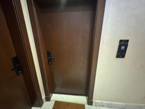 a hallway with a door with a pay phone on it at شقة هادئة بصالة وغرفة نوم in Jeddah