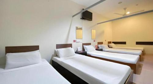 a room with three beds in a room at SPOT ON 91178 Motel Impian in Seri Manjung