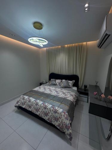 a bedroom with a large bed and a television at شقة هادئة بصالة وغرفة نوم in Jeddah