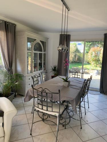 Maison L في Treillières: غرفة طعام بها طاولة وكراسي