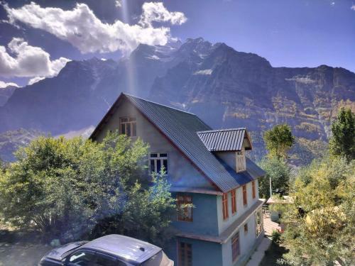 a house with a car parked in front of it at Snow Peaks View Home Stay in Gondla