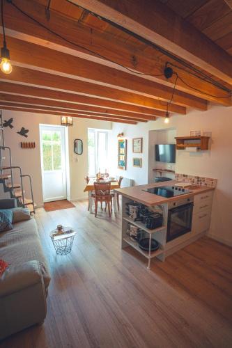 a kitchen and living room with a couch and a table at Le Petit Gite du Roy in Courlay