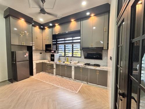 a kitchen with stainless steel appliances and a wooden floor at Danish Villa in Kota Bharu