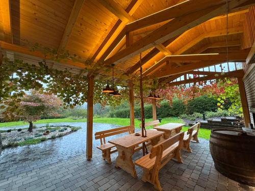 a wooden pergola with a table and benches on a patio at Hiša na Hribu- A Peaceful Hilltop Escape above river Kolpa in Kostel