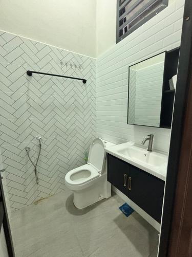 a bathroom with a toilet and a sink and a mirror at Danish Villa in Kota Bharu