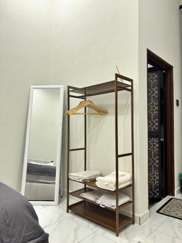 a room with a mirror and a shelf with towels at Danish Villa in Kota Bharu