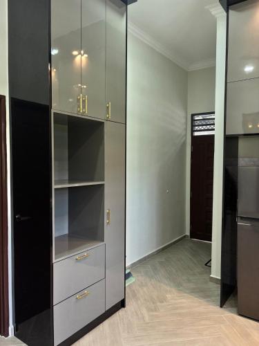 a walk in closet with glass cabinets in a room at Danish Villa in Kota Bharu