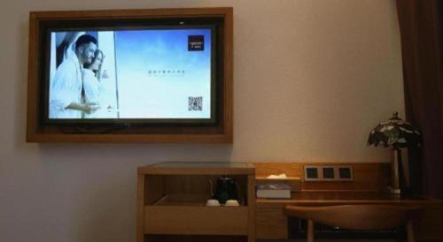 a flat screen tv hanging on a wall at James Joyce Coffetel· Hefei Anhui Agricultural University in Hefei
