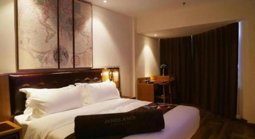 a hotel room with a large bed with white pillows at James Joyce Coffetel· Hefei Anhui Agricultural University in Hefei