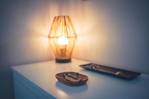 a table with a lamp and a wooden bowl on it at Le Petit Gite du Roy in Courlay
