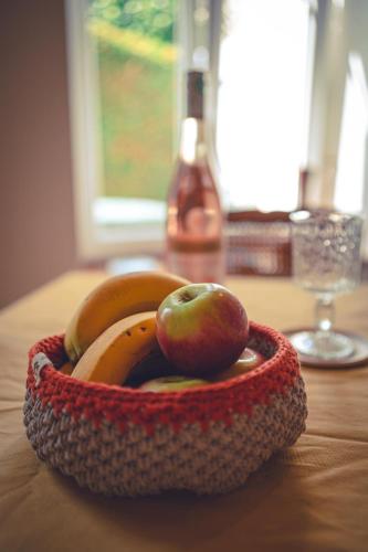 a bowl of fruit with an apple and bananas on a table at Le Petit Gite du Roy in Courlay