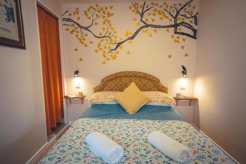 a bedroom with a bed with a tree mural on the wall at Le Petit Gite du Roy in Courlay