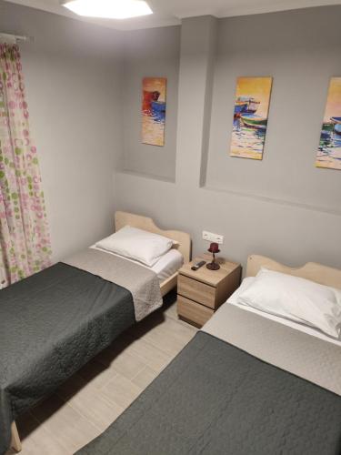 a bedroom with two beds and a lamp on a night stand at Neapolis Apartment in Kavála