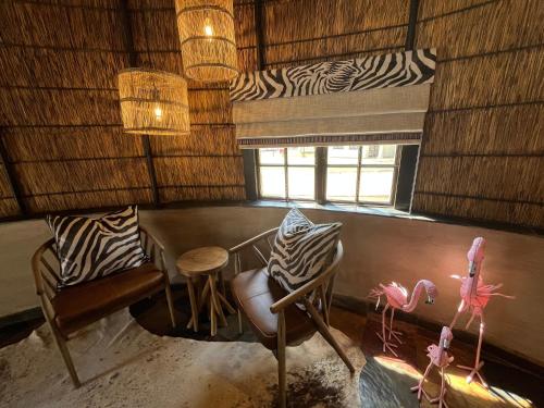 a room with chairs and a table and a window at Kievits Kroon Gauteng Wine Estate in Pretoria