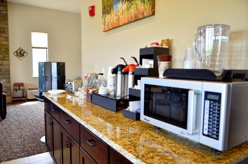 a kitchen counter with a microwave on top of it at Cobblestone Inn & Suites - Monticello in Monticello